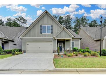 Charming, single-story home boasts a manicured lawn, attached garage and welcoming front porch at 3112 Patriot Sw Sq, Marietta, GA 30064