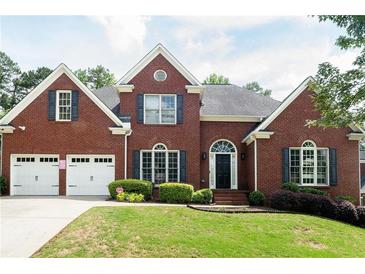 Beautiful red brick home with black shutters, a two-car garage and a well-maintained lawn at 4046 Creekview Ridge Dr, Buford, GA 30518