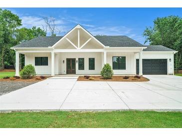 Charming single-story home features a modern farmhouse design, inviting entrance, and a spacious driveway at 4824 Se Highway 20, Conyers, GA 30013