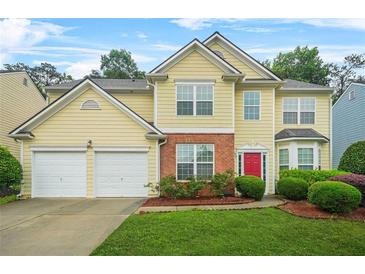 Charming two-story home featuring a red door, manicured lawn and a two car garage at 606 Hay Meadow, Acworth, GA 30102
