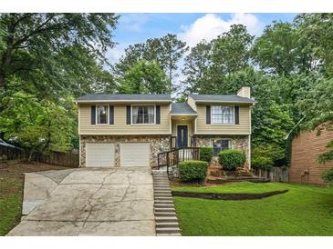 Charming two-story home featuring stone accents, a two-car garage, and a well-manicured front yard at 735 Waterbrook Ter, Roswell, GA 30076