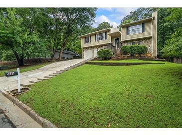 Charming home featuring a combination of stone and siding, a well-manicured lawn, and an inviting driveway at 735 Waterbrook Ter, Roswell, GA 30076