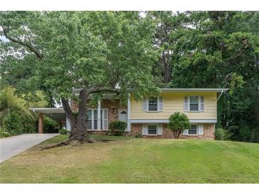 Charming yellow home with brick accents, well-manicured lawn, and mature trees offering shade and curb appeal at 2510 Brentwood Ct, Decatur, GA 30032