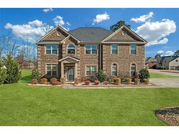 Charming two-story brick home with a manicured lawn and inviting front entrance at 4580 Cloister Cir, Hampton, GA 30228