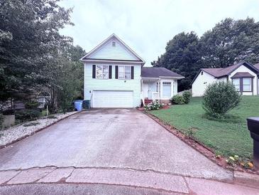 Charming two-story home featuring a well-maintained lawn, attached garage, and a long driveway at 2331 Georgia Lane, Snellville, GA 30078
