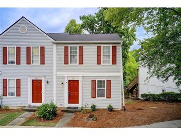 Charming two-story townhouse featuring light gray siding and red shutters, creating a welcoming curb appeal at 3999 Bayside Cir, Doraville, GA 30340