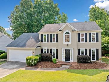 Charming two-story home with a well-manicured lawn, lush landscaping, and a convenient two-car garage at 4780 Agate Dr, Johns Creek, GA 30022