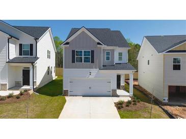 Charming two-story home featuring a one car garage and manicured front lawn at 12085 Conrad Circle, Hampton, GA 30228