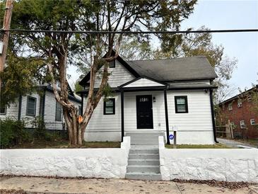 Charming renovated home with a black front door, gray stairs, and a manicured stone wall at 701 Cameron M Alexander Nw Blvd, Atlanta, GA 30318