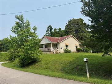 Charming single-story home featuring a cozy porch, lush lawn, and mature trees at 361 West Ave, Dallas, GA 30157