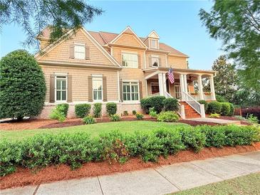 Inviting two-story home featuring a covered porch, landscaped yard, and neutral-toned exterior at 4530 Westgate Dr, Cumming, GA 30040