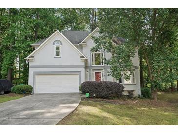 Charming two-story home with a well-maintained lawn, two car garage and a welcoming red front door at 220 Chinkapin Sw Cir, South Fulton, GA 30311