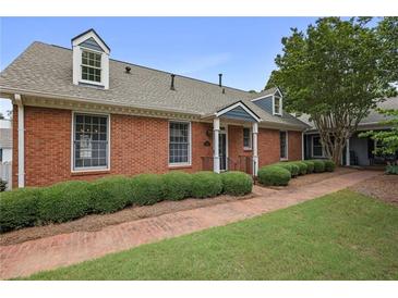 Charming brick home featuring a well-manicured front yard and traditional architectural details at 460 Chowning Nw Pl, Marietta, GA 30064
