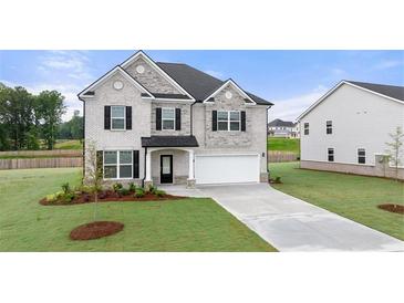 Beautiful two-story home boasts a brick facade, well-manicured lawn, and a spacious two-car garage at 291 Sandy Oak Dr, Loganville, GA 30052