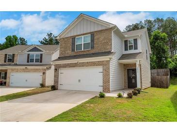 Charming two-story home boasts a brick and siding exterior, complemented by a two-car garage and a well-maintained lawn at 10814 Wheeler Trce, Hampton, GA 30228