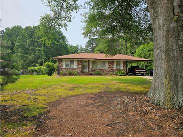 Charming brick home with a well-maintained lawn and covered parking at 2323 Cedar Terrace Rd, Lithia Springs, GA 30122