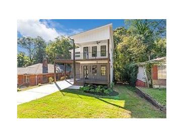 Striking two-story home with a modern design, balconies, well-kept lawn, and lush, mature trees around the property at 1464 Ezra Church Nw Dr, Atlanta, GA 30314