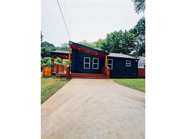 Charming home with a modern design, featuring a covered porch and well-manicured lawn at 2228 Carey Se Dr, Atlanta, GA 30315