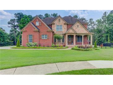 Beautiful brick and stone home with lush lawn and manicured landscaping at 1283 Silver Trace Sw Dr, Lilburn, GA 30047