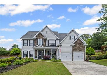 Traditional two-story home with stone accents, attached two car garage, well-manicured lawn, and inviting curb appeal at 121 Bradshaw Park Dr, Woodstock, GA 30188