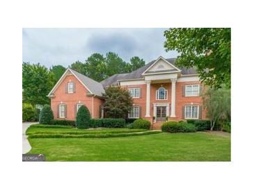 Stately brick home featuring a meticulously landscaped front yard and classic architectural details at 6205 Arnall Nw Ct, Acworth, GA 30101
