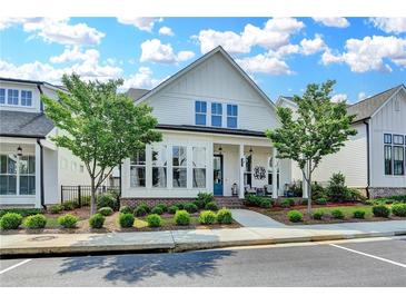 Charming two-story home featuring a welcoming front porch and manicured landscaping at 1002 Harvest Park Ln, Suwanee, GA 30024