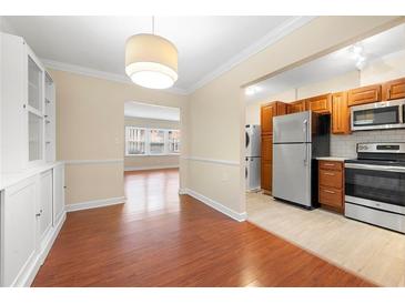 Bright dining area features hardwood floors, built-in cabinets and a view to the kitchen with stainless steel appliances at 2355 Henderson Mill Ne Rd # 6, Atlanta, GA 30345