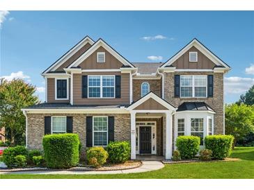 Charming two-story home with a brick and siding exterior, manicured landscaping, and a welcoming front porch at 3134 Flery Way, Lawrenceville, GA 30046