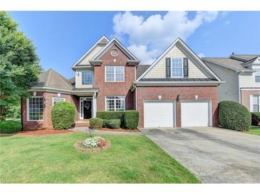 Charming brick two-story home featuring a well-manicured lawn and a two-car garage at 708 Edgeley Ln, Lawrenceville, GA 30044