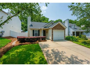 Charming single-Gathering home featuring a well-manicured lawn, stone accents, and a cozy front porch at 2305 Keenland Ct, Cumming, GA 30040