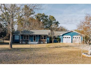 Charming blue single story home with a large yard and a two-car garage at 110 Fox Meadow Dr, Covington, GA 30016