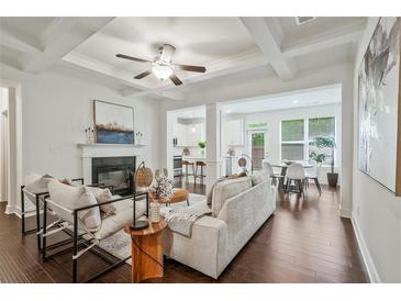 Bright living room features a fireplace, modern furniture, and open access to the kitchen and dining area at 2235 Mulsanne Dr, Lithonia, GA 30058