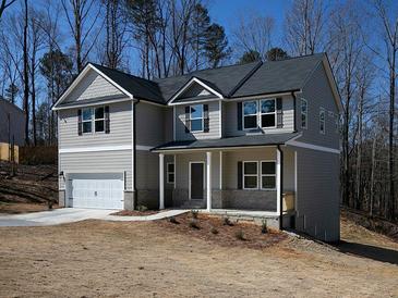 Charming two-story home features a covered porch, attached garage, and neutral siding, creating an inviting curb appeal at 250 Shawnee Trl, Dallas, GA 30157