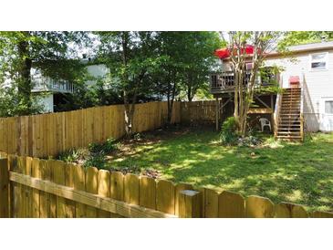 Fenced backyard with grass and mature trees offers a private outdoor space at 1425 Parkmont Dr, Roswell, GA 30076