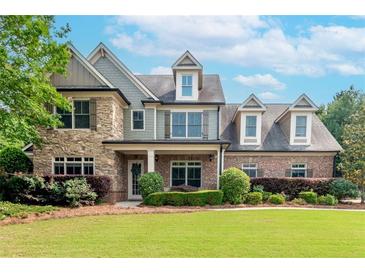 Charming two-story home with a manicured lawn, professional landscaping and mixed brick and stacked stone details at 1771 Silvergrass Ln, Grayson, GA 30017