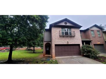 Charming two-story brick home with a covered entry, two car garage, and landscaped front yard at 5719 Singlebriar Ct, Norcross, GA 30093