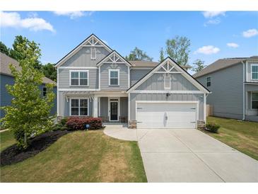 Charming two-story home features a landscaped yard, gray siding, and a two-car garage, offering excellent curb appeal at 193 Treeline Trl, Canton, GA 30115