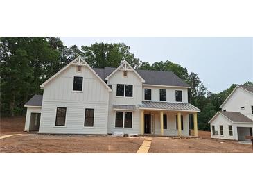 New construction shows a bright, two-story farmhouse-style home with a covered front porch and black-framed windows at 4615 Greyson Manor Dr, Cumming, GA 30041