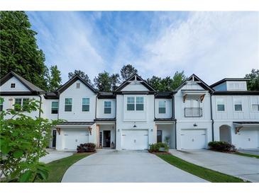 Charming townhomes featuring white exteriors, driveways, and well-maintained landscaping at 4175 Spring Valley Cir, Tucker, GA 30084