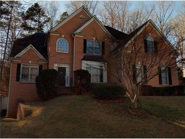 Charming two-story brick home with black shutters, landscaped yard, and mature trees in a desirable neighborhood at 7071 Glen Cove Ln, Stone Mountain, GA 30087