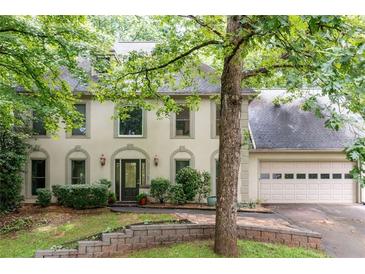 Charming two-story home featuring a well-manicured lawn and traditional architectural details at 735 Wood Valley Trce, Roswell, GA 30076