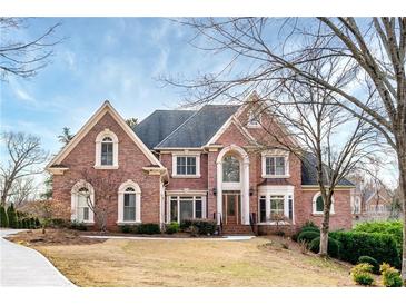 Charming two-story brick home with landscaped yard, gabled roof, and an inviting entrance at 2760 Sugarloaf Club Dr, Duluth, GA 30097