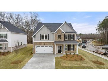 Beautiful two-story home with brick and siding exterior, well-manicured lawn, and attached two-car garage at 13574 Se Whitman Ln, Covington, GA 30014