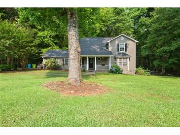 Charming two-story home features a welcoming front porch and well-maintained lawn at 135 Dunwick Ln, Mcdonough, GA 30253