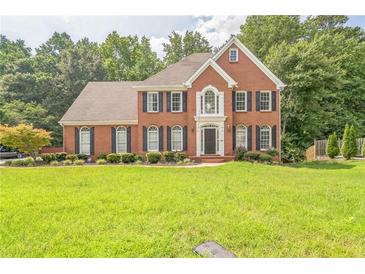 Beautiful brick home with a manicured lawn and mature trees in a desirable neighborhood at 2260 Cobble Creek Ln, Grayson, GA 30017