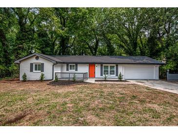 Charming, newly renovated single-story home featuring a bright orange front door and modern exterior paint at 5640 Redan Cir, Stone Mountain, GA 30088