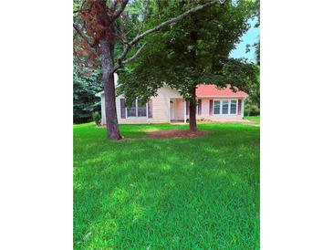 Charming single-story home with lush lawn and mature trees in a serene setting at 6103 Chaseland Dr, Rex, GA 30273