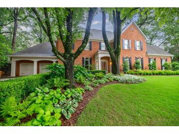Stately brick home featuring a well manicured lawn and flower beds, creating a welcoming curb appeal at 663 Clifton Ne Rd, Atlanta, GA 30307