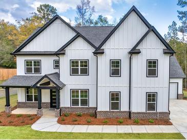 Charming two-story home featuring white siding, black trim, and a well-manicured front yard at 1387 Mineral Springs Rd, Hoschton, GA 30548