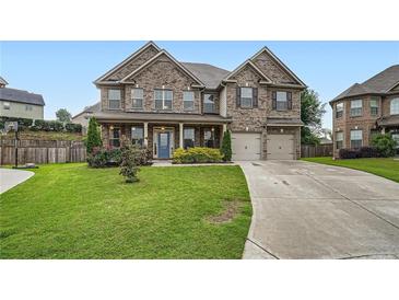 Charming two-story brick home featuring a manicured lawn and a welcoming front porch at 5445 Whisper Ct, Cumming, GA 30028